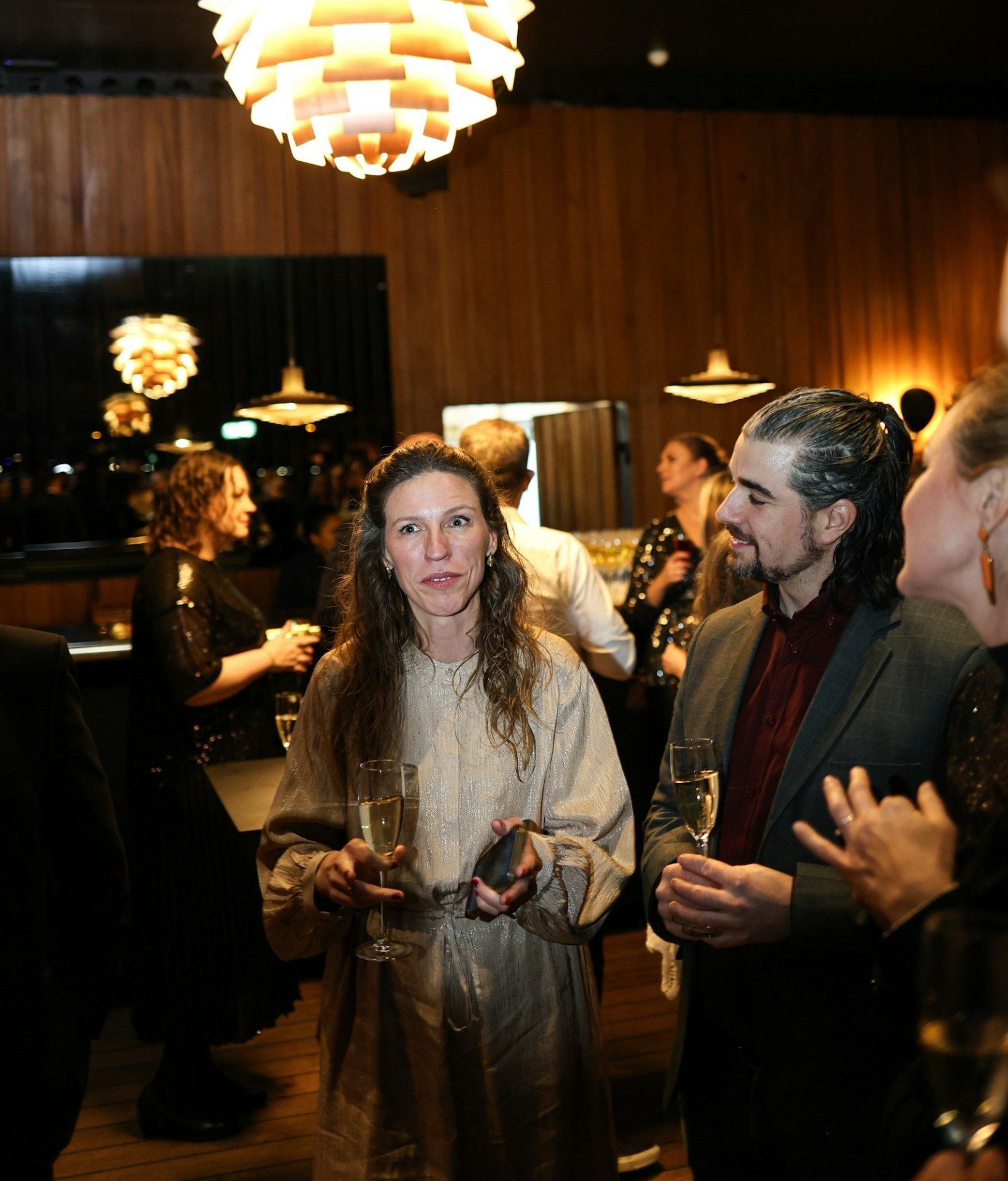 People holding champagne glasses at a gathering